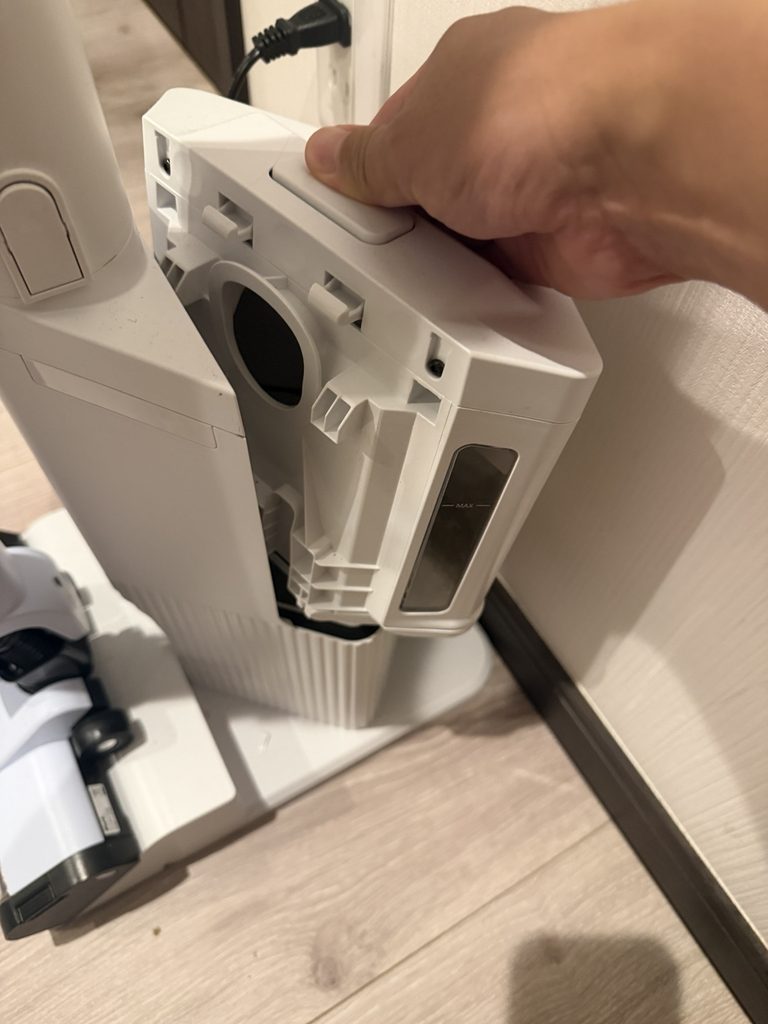 自動ゴミ収集ドックのダストカップを取り外している様子